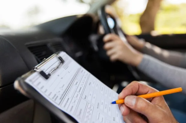 Instructor recording observations during a mock driving test