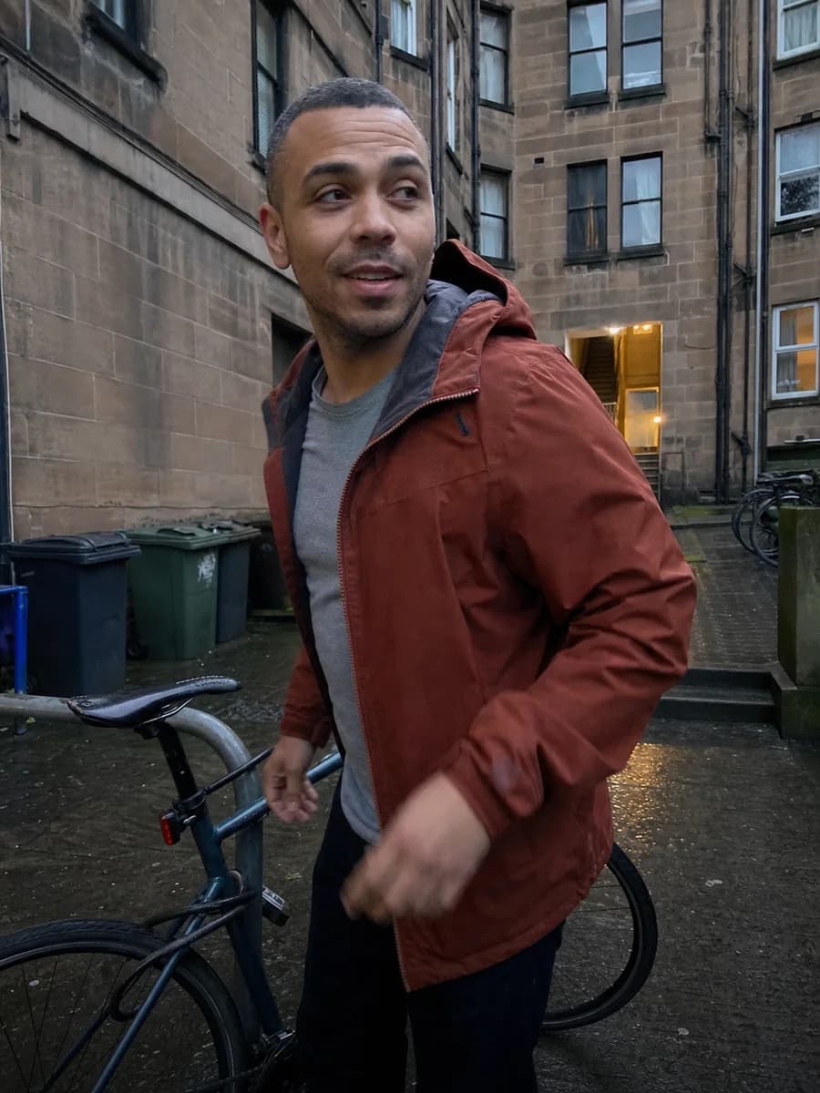 Illustrative learner standing beside a bicycle in a Glasgow courtyard