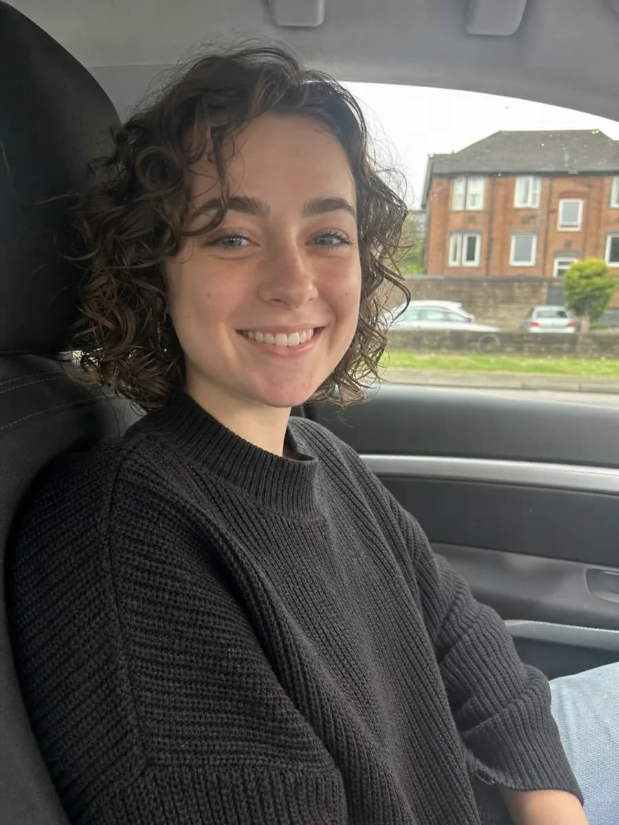 Illustrative learner relaxing in the passenger seat of a parked car