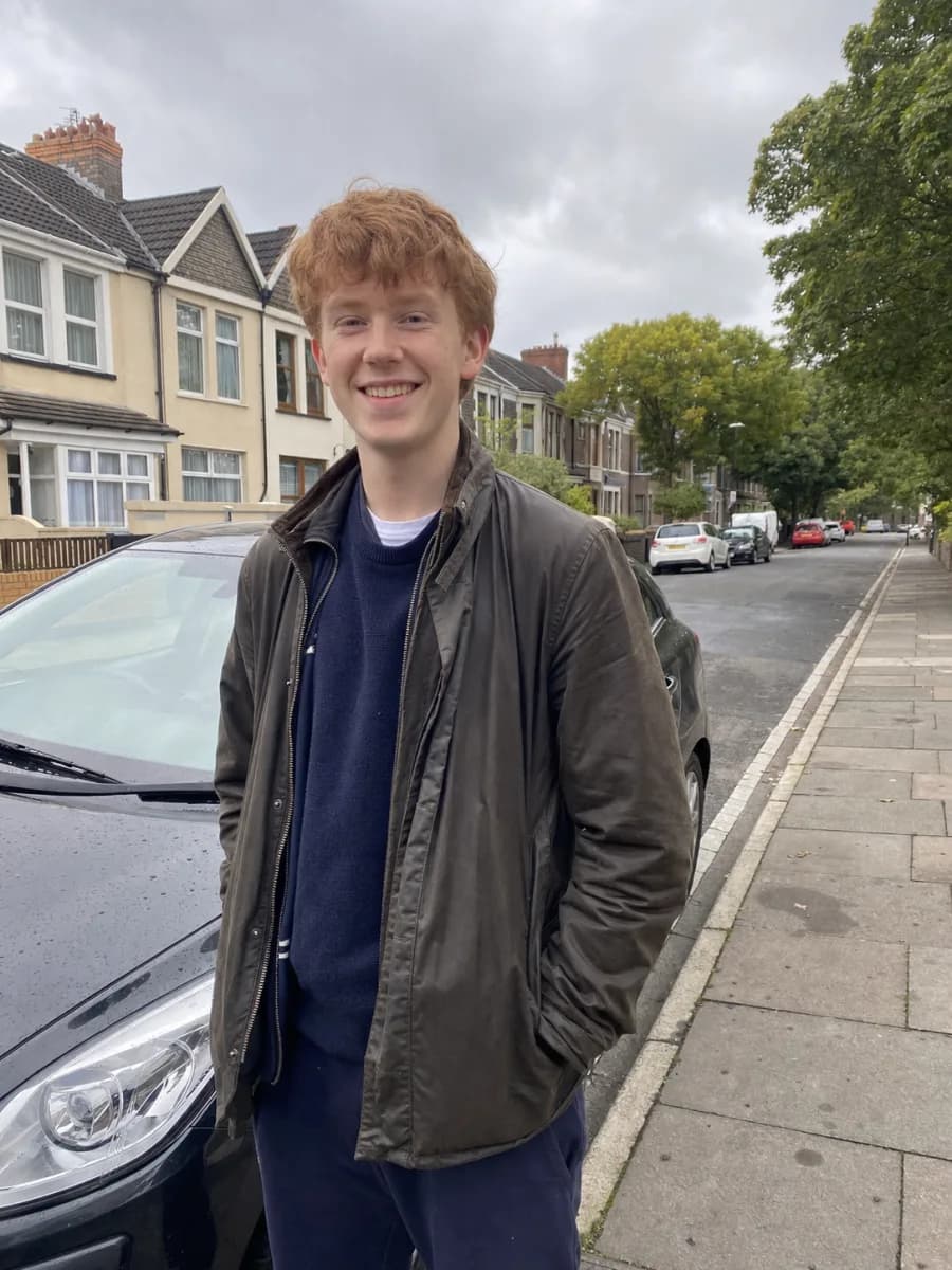 Illustrative learner standing on a residential street